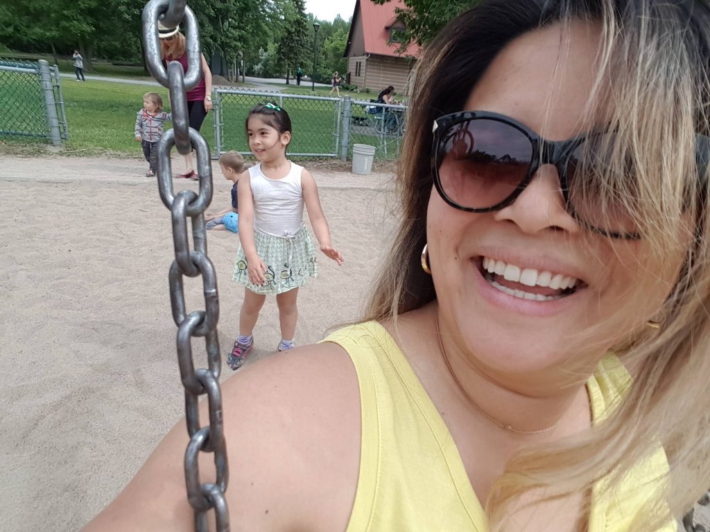 daughter pushing her mom on a swing, family time