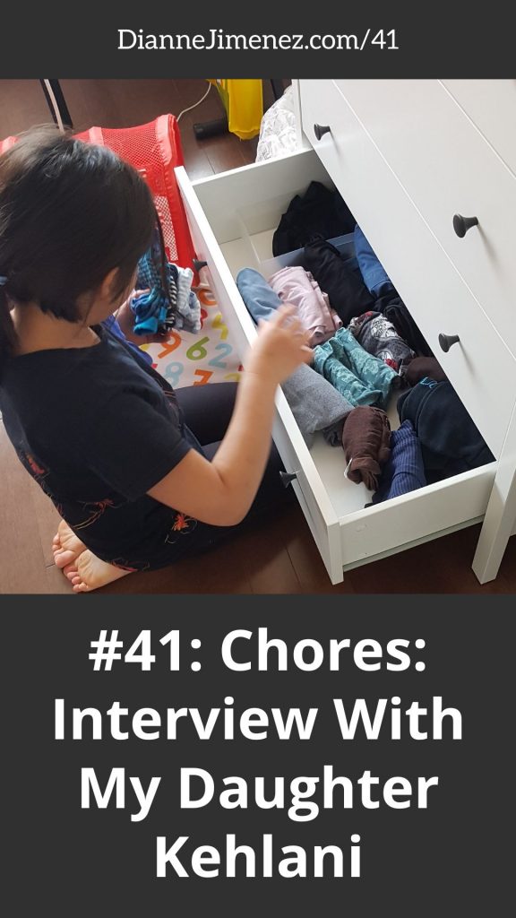 little girl putting away her folded clothes as part of her chores