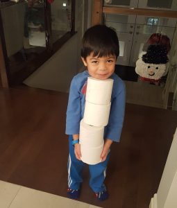 little boy carrying 4 rolls of toilet paper, kids helping out at home